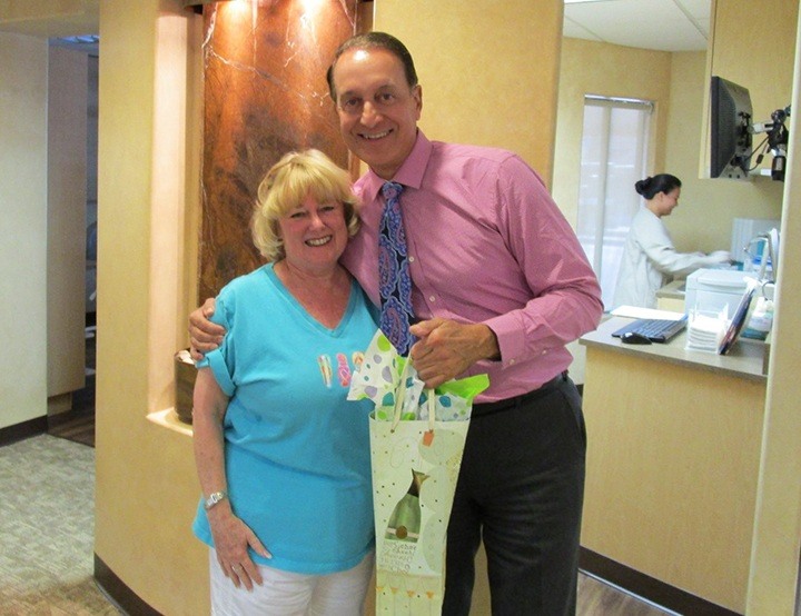 Dr. Canzoneri giving patient a gift