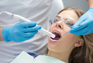Dentist capturing intraoral photos of woman's smile