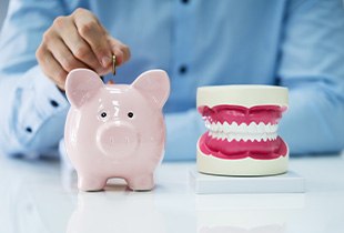 Patient saving money in piggy bank for teeth whitening treatment