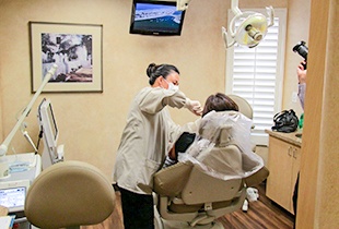 Dentist providing treatment for patient in dental chair