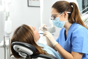 dental hygienist cleaning a patient’s teeth