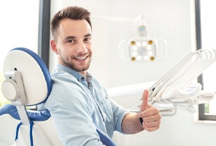 man giving a thumbs-up in the dental chair