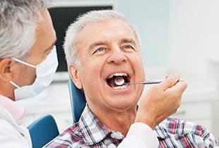 Person holding a mouth mold with an implant denture 