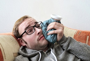 man holding a cold compress to his face