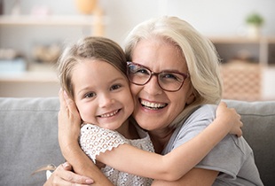 older woman smiling with granddaughter after getting dental implants in Arcadia