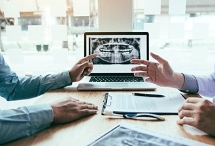 Two dentists discussing the cost of dental implants in Arcadia.