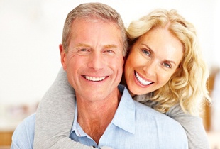 An older couple smiling and hugging.