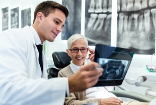 A dentist showing an older patient an X-ray.