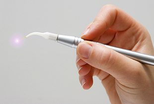 Hand holding dental laser