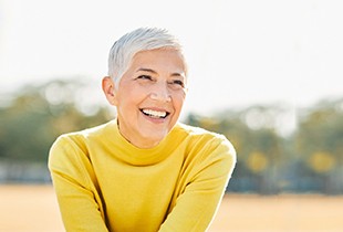 A smiling senior woman sitting outdoors