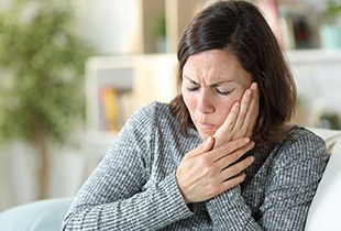 A middle-aged woman having a toothache at home