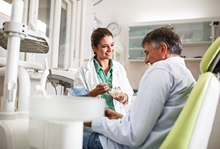 A dentist preparing an older man for a dental treatment