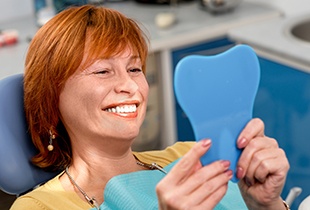 Senior woman looking at smile in mirror