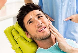 Man holding jaw in pain