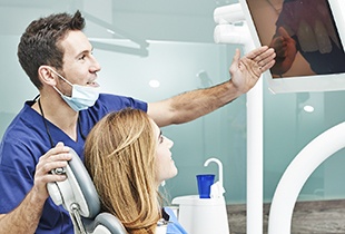 Dentist showing patient x-rays on computer