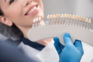 dentist determining shade of patient's teeth