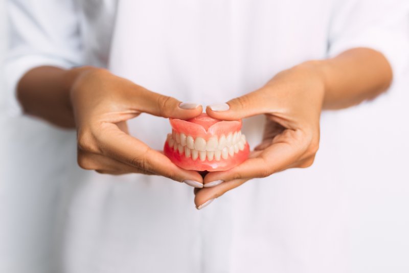 Dentist holds dentures