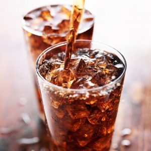 A glass of cola containing ice.