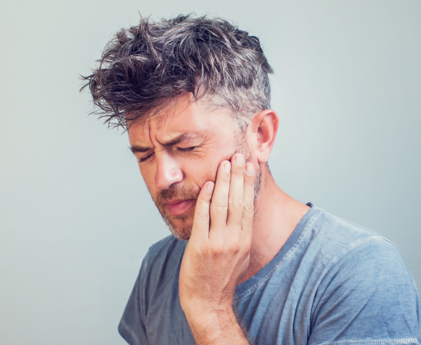 Man holding jaw in pain