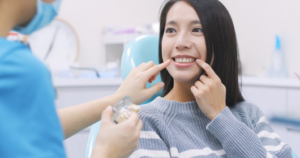 Patient pointing to her teeth to indicate to dentist what she wants
